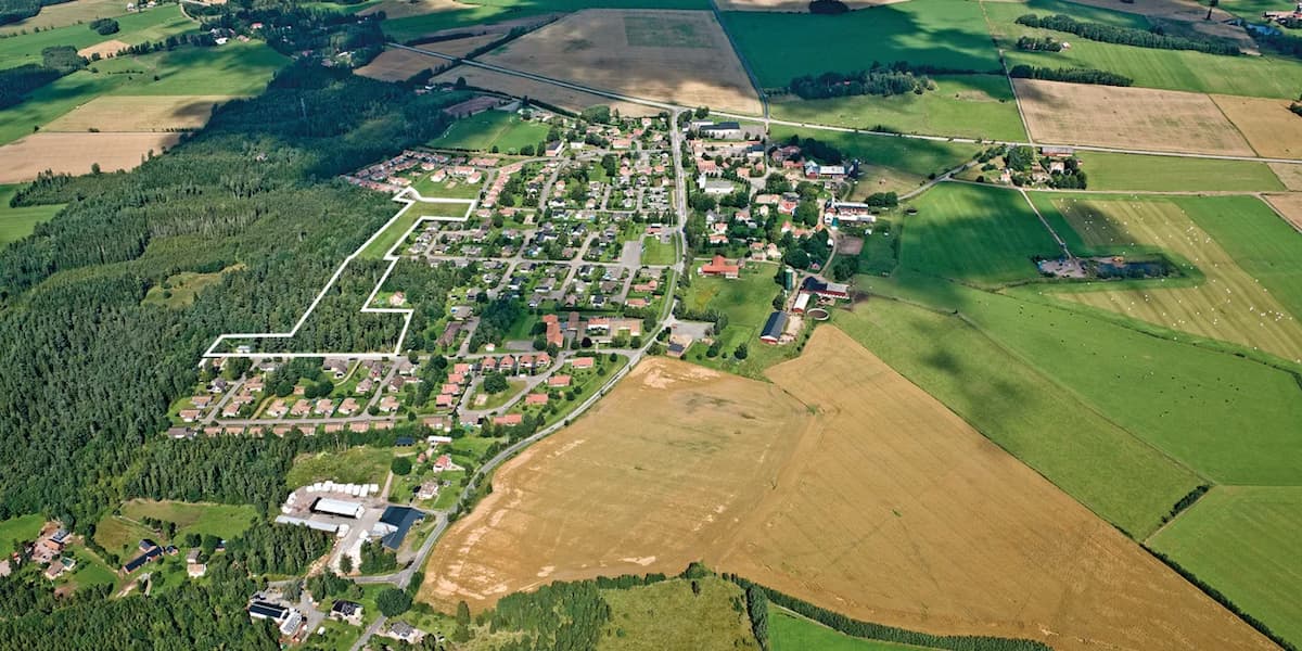 En flygbild av en liten stad omgiven av fält