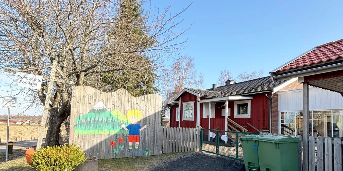 Ett rött hus med en färgstark väggmålning på sidan av det