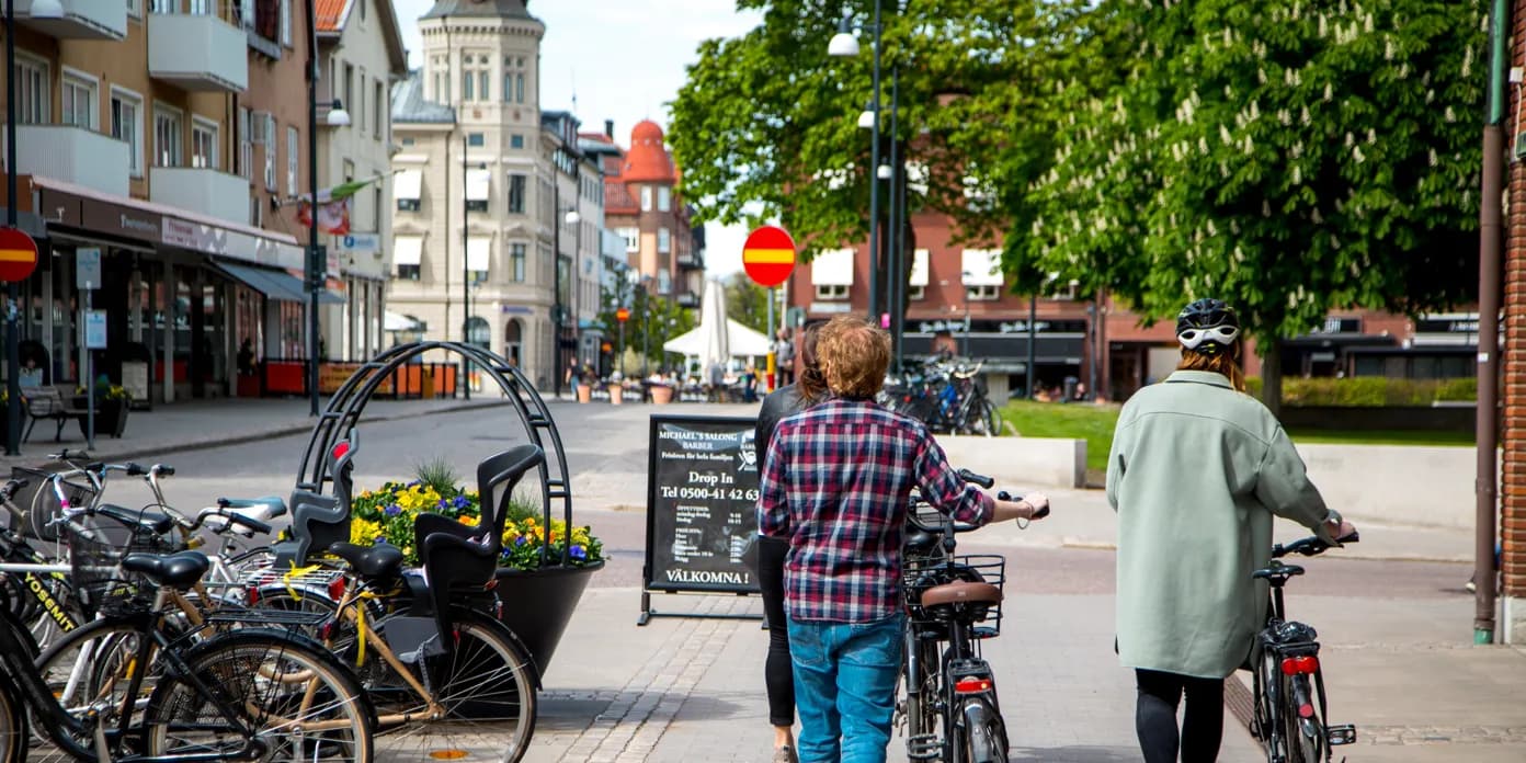 Några personer som går längs en gata med cyklar