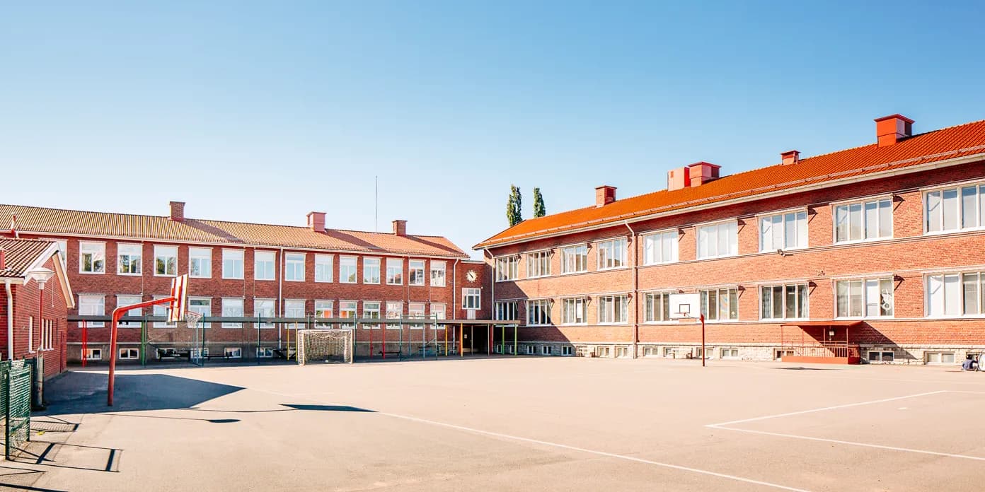 En skolgård framför en röd tegelbyggnad